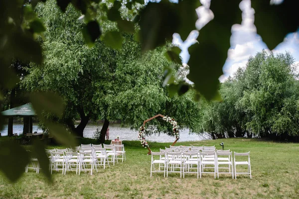 一个举行露天婚礼的漂亮场地 在可以俯瞰河流的绿色草坪上 有一个婚礼拱门和一排客房椅子 高质量的照片 — 图库照片