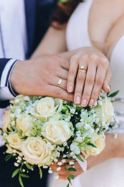 Gelin ve damat düğün çiçeklerini evlilik yüzüklerini göstermek için teslim ediyor. Yüksek kalite fotoğraf