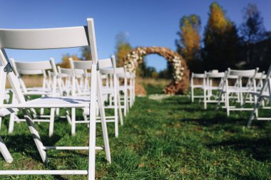 Düğün töreni. Çok güzel ve şık bir düğün kemeri, çeşitli taze çiçeklerle süslenmiş, bahçede duruyor. Düğün günü. Taze çiçek süslemeleri, şakayıklama. Yüksek kalite fotoğraf