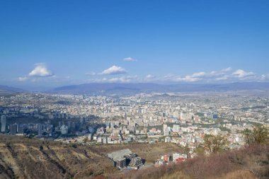 Şehir manzaralı. Tiflis, Georgia. Sonbahar şehri manzarası. Dağların arasında bir şehir. Mavi gökyüzü.