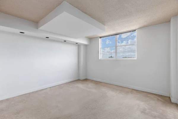 empty room with window with sky in the background, white walls, carpeted floor and beige ceiling, wall with 4 lights, ideal shot for office or bedroom rendering