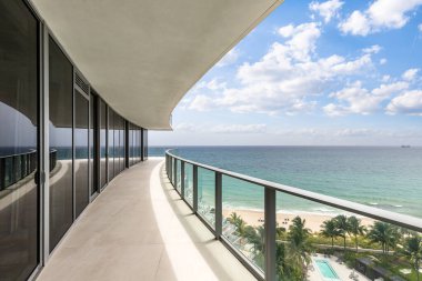 Denize ve Miami plajına bakan balkon manzarası, ufuk çizgisi turkuaz deniz ve mavi gökyüzü