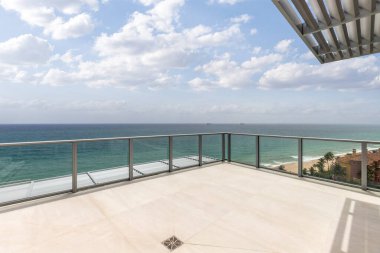 Denize ve Miami plajına bakan balkon manzarası, ufuk çizgisi turkuaz deniz ve mavi gökyüzü