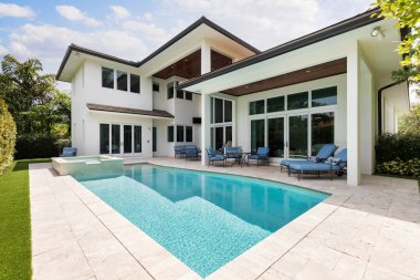 Havuzlu arka bahçe, yapay çimler, ağaçlar ve sandalyeler, güneş pansiyonları, spa