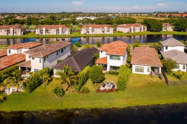 Miami 'deki çam ağaçlarının, modern lüks semtin sömürge ve yerleşim yerlerinin havadan görünüşü, evlerin arkasında kanallar ve büyük tropikal bitkiler var.