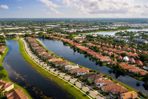 Aerial view of suburb of pembroke pines in miami, of colonial and residential style houses of modern luxury neighborhood, with canals in the back of the houses, with large tropical plants