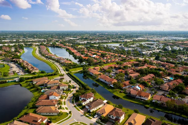 Aerial view of suburb of pembroke pines in miami, of colonial and residential style houses of modern luxury neighborhood, with canals in the back of the houses, with large tropical plants