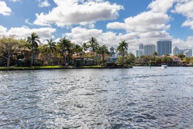 Fort Lauderdale, Miami 'deki yeni nehir manzarası sörf, tekne, rıhtım, tropikal tesisler, binalar ve modern evler.