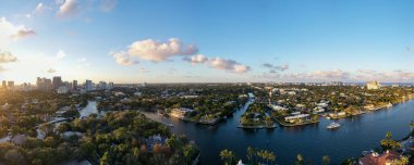 Fort Lauderdale, Miami 'deki yeni nehrin panoramik manzarası, dalgalar, tekneler, rıhtımlar, tropikal tesisler, binalar ve modern evler.