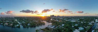 Fort Lauderdale, Miami 'deki yeni nehrin panoramik manzarası, dalgalar, tekneler, rıhtımlar, tropikal tesisler, binalar ve modern evler.