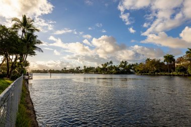 Fort Lauderdale, Miami 'deki yeni nehir manzarası sörf, tekne, rıhtım, tropikal tesisler, binalar ve modern evler.