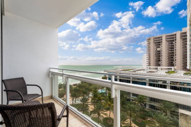 Modern binalar, tropikal bitkiler ve mavi gökyüzü ile balkondan Miami 'nin deniz ve plajına manzara