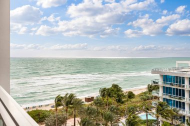 Modern binalar, tropikal bitkiler ve mavi gökyüzü ile balkondan Miami 'nin deniz ve plajına manzara