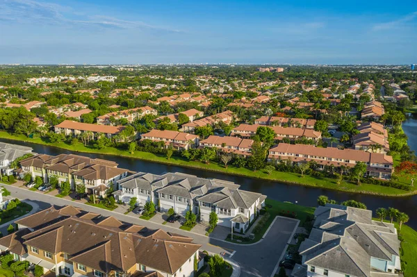 Aerial drone view of suburbs in Boca Pointe neighborhood of Boca Raton, Miami, canal and lagoon, tropical vegetation, blue sky