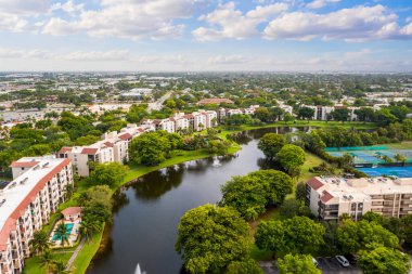 Miami Florida Delray Sahili 'nin banliyölerine insansız hava aracı görüntüsü. Büyük tropikal bitki örtüsü, fayanslı evler ve mavi gökyüzü var.