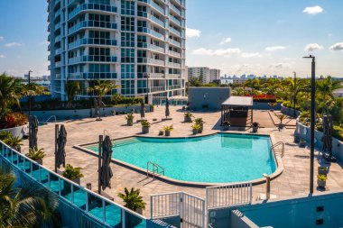 Miami 'deki North Bay Village' ın insansız hava aracı görüntüsü, modern binalar ve kuleler, köprüler, deniz, yüzme havuzu ve şemsiyeler, botlar, palmiyeler ve tropikal bitkiler, kentsel gökyüzü ve mavi gökyüzü.