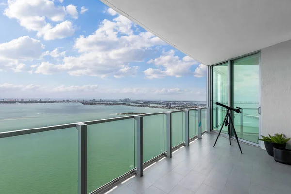 Beautiful view of the sea from balcony, with glass railing, telescope and decorative plants, urban landscape in miami islands