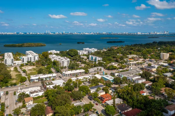 Aerial shot of Upper East Side residential neighborhoodin Miami, lush vegetation is seen, modern buildings, luxury houses, urban skyline, blue sky, street with cars