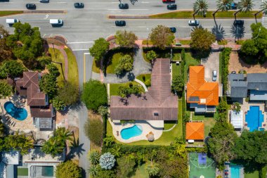 Miami Beach 'teki La Gorce mahallesinin hava aracı görüntüsü, kanallar, deniz, bol tropikal bitki örtüsü, palmiyeler, ağaçlar, modern binalar ve kuleler, limanlar, mavi gökyüzü.