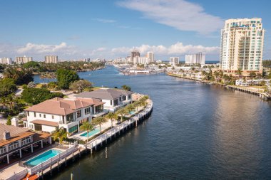 Fort Lauderdale 'deki Harbor Beach' in hava aracı görüntüsü, yeni nehir manzaralı malikaneler, modern binalar, kuleler, mavi gökyüzü.