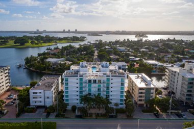 Miami-Dade 'deki Liman Koyu Adası' nın insansız hava aracı görüntüleri, liman manzaralı lüks evler ve binalar, adalar, golf sahaları, botlar, rıhtımlar, mavi gökyüzü.