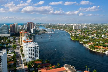 Aerial drone shot of miami coastline with towers and modern buildings, blue sky, bay, waves