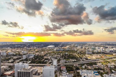 Aerial drone view of Downtown Miami, with spectacular modern and luxurious buildings and towers, streets with cars, sea in the background with blue and imposing sky
