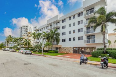West Bay building facade in the South Beach neighborhood of Miami, white buildings with balconies, condominiums, towers, trees and palm trees around