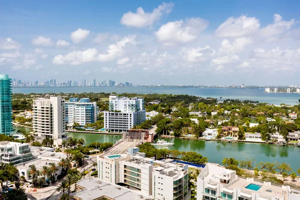 Aerial drone view of the North Beach beaches in Miami Beach, building known as Akoya, turquoise sea, umbrellas, modern buildings and towers around, blue sky