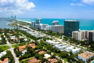 Bal Limanı villası, apartman daireleri, zarif evler, tropikal bitki örtüsüyle çevrili modern kuleler, yaz havası, tekneleri ve iskeleleri olan körfez, turkuaz deniz ve mavi gökyüzü.