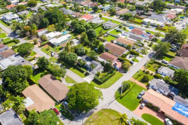 Batı Flagler mahallesinde, Little Havana 'da, modern evlerin, kısa otların, banliyölerin, ağaçların, palmiye ağaçlarının, sokakların ve park halindeki arabaların hava aracı görüntüleri.