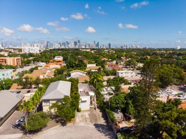 Miami 'deki Mercan Yolu' nun hava aracı görüntüleri garaj yolu, merdivenler, palmiyeler, cyan duvarlar, ahşap çitler, arka planda mavi gökyüzü, çevrede bol miktarda bitki örtüsü.