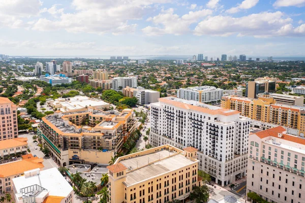 Aerial drone shot of the urban area of Coral Gables, with a large number of modern buildings and towers, surrounded by a large amount of tropical vegetation, blue sky
