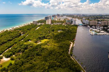 Coral Ridge mahallesinin, Fort Lauderdale, Miami, ABD 'deki ticari alanının, kanalların ve teknelerin, lüks evlerin ve malikanelerin, bol tropikal bitki örtüsünün, mavi gökyüzünün havadan çekilmiş görüntüsü.