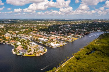 Coral Ridge mahallesinin, Fort Lauderdale, Miami, ABD 'deki ticari alanının, kanalların ve teknelerin, lüks evlerin ve malikanelerin, bol tropikal bitki örtüsünün, mavi gökyüzünün havadan çekilmiş görüntüsü.