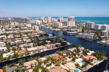 Coral Ridge mahallesinin, Fort Lauderdale, Miami, ABD 'deki ticari alanının, kanalların ve teknelerin, lüks evlerin ve malikanelerin, bol tropikal bitki örtüsünün, mavi gökyüzünün havadan çekilmiş görüntüsü.