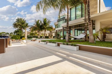 Florida, USA. Modern building with swimming pool, trees, chairs. Urban landscape with blue reflecting pool, city architecture, and scenic environment.