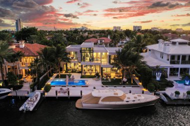 Aerial drone Shoot in Florida, USA, commercial area, luxury houses, buildings and mansions, abundant tropical vegetation around, blue sky and Ocean.