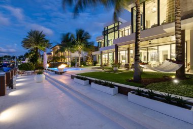 Florida, USA. Modern building with swimming pool, trees, chairs. Urban landscape with blue reflecting pool, city architecture, and scenic environment.