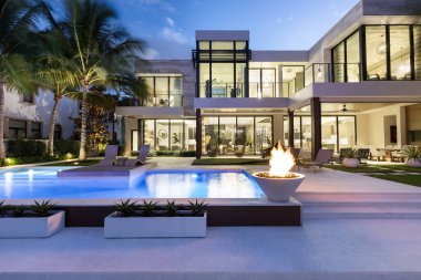 Florida, USA. Modern building with swimming pool, trees, chairs. Urban landscape with blue reflecting pool, city architecture, and scenic environment.