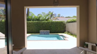Florida, USA. Modern building with swimming pool, trees, chairs. Urban landscape with blue reflecting pool, city architecture, and scenic environment.