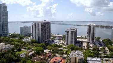 Florida, ABD 'deki hava aracı görüntüleri, ticari alan, lüks evler, binalar ve malikaneler, çevrede bol miktarda tropikal bitki örtüsü, mavi gökyüzü ve okyanus.