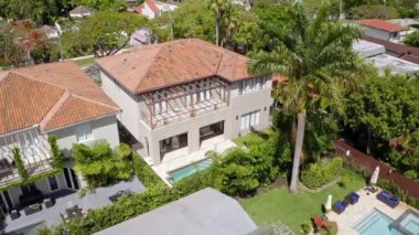 Florida, ABD 'deki hava aracı görüntüleri, ticari alan, lüks evler, binalar ve malikaneler, çevrede bol miktarda tropikal bitki örtüsü, mavi gökyüzü ve okyanus.