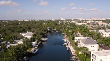 Fort Lauderdale, Florida, ABD 'deki hava aracı görüntüleme evi, ticari alan, lüks evler, binalar ve malikaneler, etraftaki tropikal bitki örtüsü, mavi gökyüzü ve okyanus.