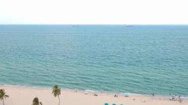 Florida, ABD 'deki hava aracı videosu, ticari alan, lüks evler, binalar ve malikaneler, mavi gökyüzü, okyanus ve tekneleri olan güzel bir sahilde bol miktarda tropikal bitki örtüsü..