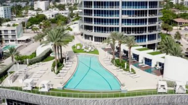 Florida, ABD 'deki hava aracı videosu, ticari alan, lüks evler, binalar ve malikaneler, mavi gökyüzü, okyanus ve tekneleri olan güzel bir sahilde bol miktarda tropikal bitki örtüsü..