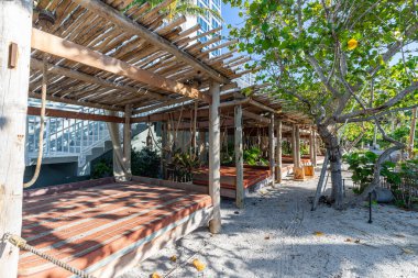 Palmiye ve şemsiyeli tropik ada plajı