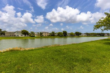 Florida, Usa 'daki Photoshoot Hava Aracı görüntüsü geniş bir bitki örtüsüyle çevrili bir su kanalındaki çoklu binalarla gökyüzünü gösteriyor..