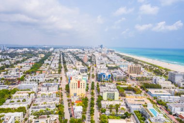 Florida, ABD 'deki hava aracı fotoshoot görüntüleri, ticari alan, lüks evler, binalar ve malikaneler, çevrede bol miktarda tropikal bitki örtüsü, mavi gökyüzü ve botlu su kanalı.