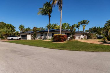 Modern mimari tasarım, ahşap mobilya, güzel yeşil bitki örtüsü, Mavi gökyüzü bulutları ve doğa sergilenmektedir..